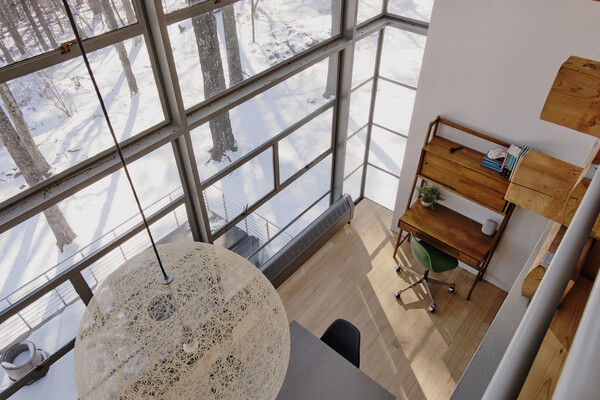 The home's glass wall extends across two stories, totaling sixteen feet tall.