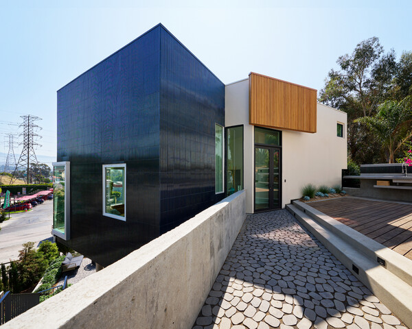 A deck and stone pathway separate the ADU from the primary residence.