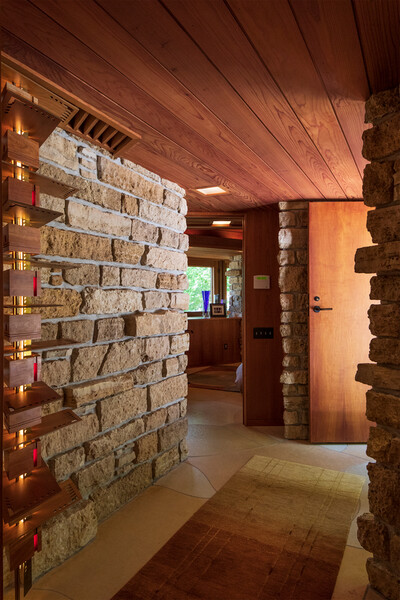 The limestone blocks on the exterior extend into Bear Run's entrance, which captures Wright's signature use of compression.